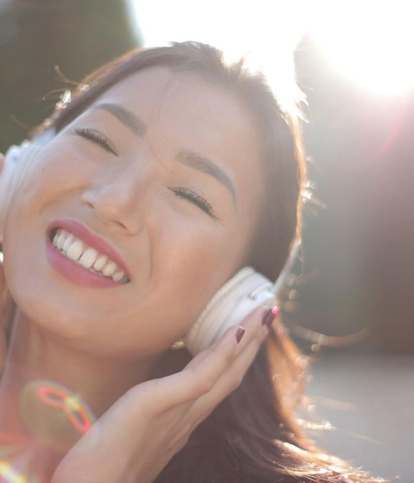 Smiling person enjoying a moment of calm outdoors.